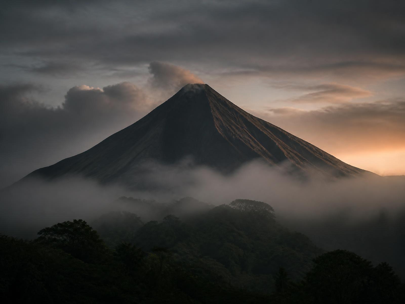 A volcano rising above cloud forest at first light